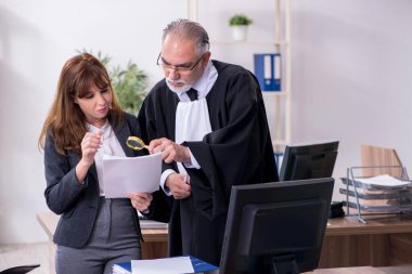 Yaşlı erkek yargıç ve genç sekreteri ofiste.