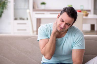 Genç adam boğaz ağrısı çekiyor.