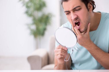 Genç adam diş ağrısı çekiyor.