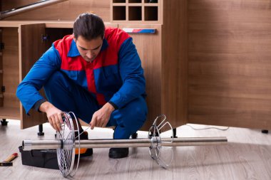 Genç yakışıklı erkek marangoz içeride çalışıyor.