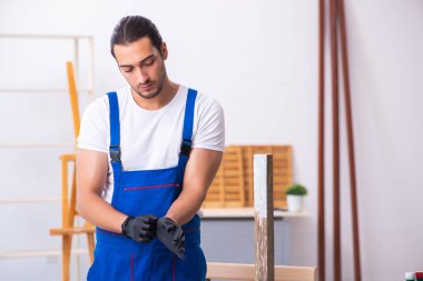 Genç erkek müteahhit atölyede çalışıyor.