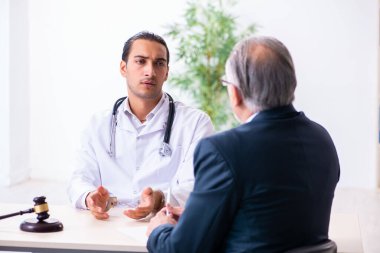 Adliyedeki erkek doktor avukatla toplantıda.