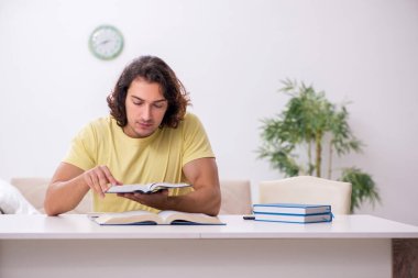 Evde sınava hazırlanan genç bir erkek öğrenci.