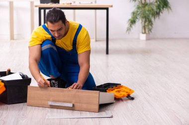 Genç erkek marangoz içeride çalışıyor.