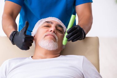 Yaşlı adam estetik ameliyat için erkek doktoru ziyaret ediyor.