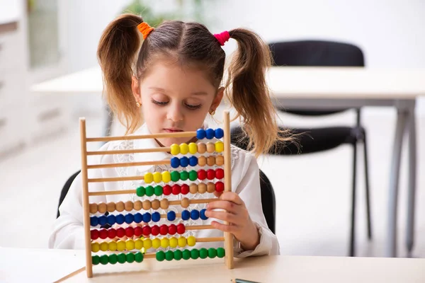 Small girl with abacus in the classroom — Stock Photo, Image