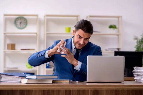 Young male employee unhappy with excessive work