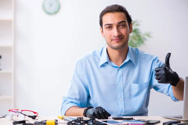 Joven técnico masculino reparando teléfono móvil — Foto de Stock