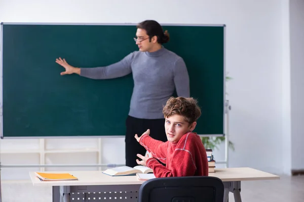 Jonge mannelijke leraar en schooljongen in de klas — Stockfoto