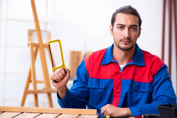 Jonge mannelijke aannemer werkzaam in werkplaats — Stockfoto