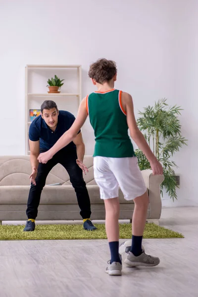 Padre e hijo haciendo ejercicios deportivos en interiores — Foto de Stock