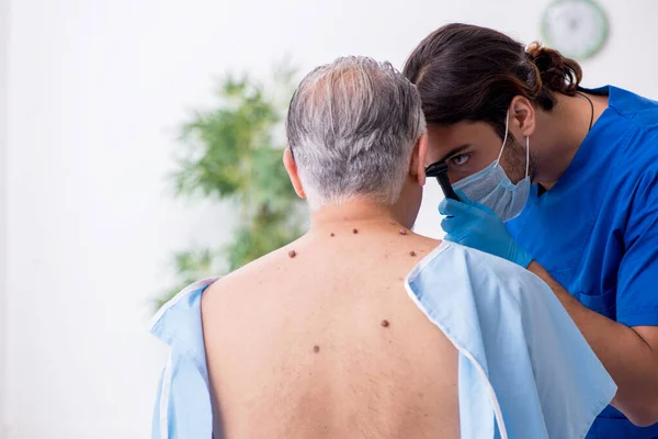 Viejo visitando joven médico dermatólogo — Foto de Stock