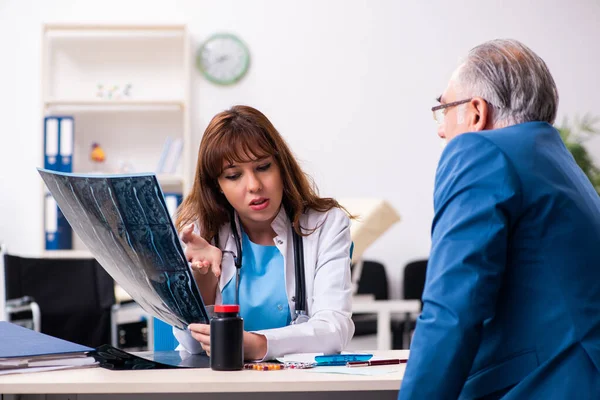 Alt unternehmer besuch jung frau doktor — Stockfoto