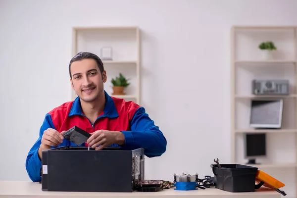 Jovem reparador do sexo masculino reparando computador — Fotografia de Stock