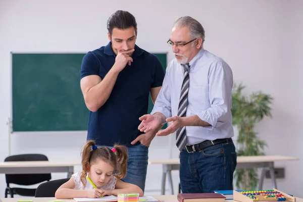 Jonge ouder, oude mannelijke leraar en klein meisje in de klas — Stockfoto