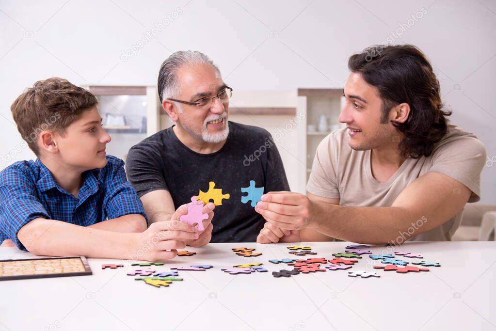 Three generations of family playing jigsaw puzzle game