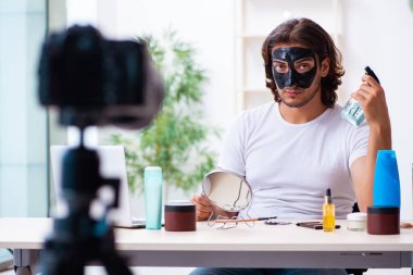 Genç erkek kozmetikçi blogu için video kaydediyor.
