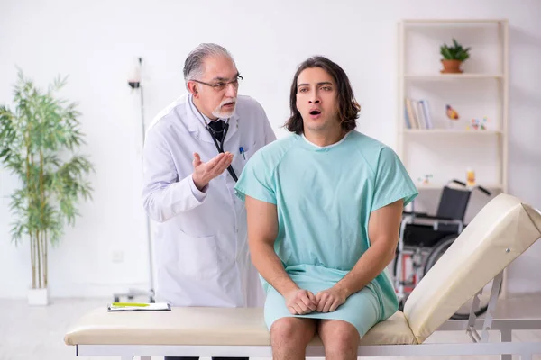 Jonge mannelijke patiënt op bezoek bij ervaren arts — Stockfoto