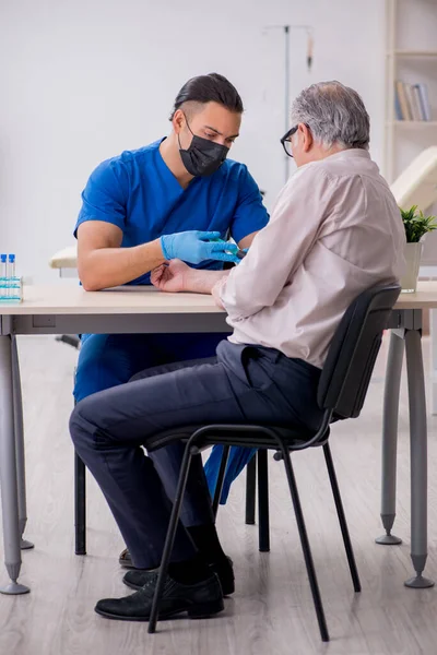 Yaşlı hasta, kan nakli için genç bir doktoru ziyaret ediyor. — Stok fotoğraf