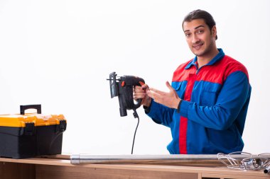 Genç yakışıklı erkek marangoz içeride çalışıyor.