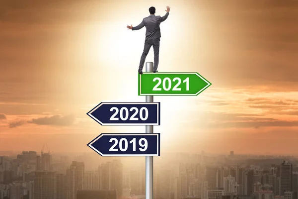 Señal de tráfico y hombre de negocios con 2020 y 2021 — Foto de Stock