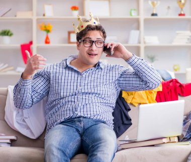 Genç adam dağınık bir odada çalışıyor.