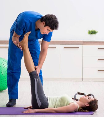 Spor hocası egzersiz sırasında sporcuya yardım ediyor.