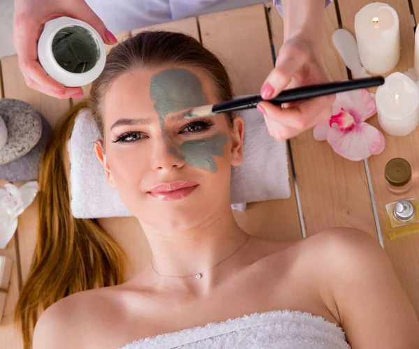 Ung kvinna i spa hälsa koncept med ansiktsmask — Stockfoto