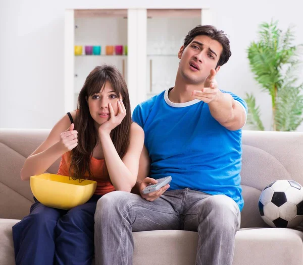 Joven hombre viendo fútbol con su esposa en casa —  Fotos de Stock