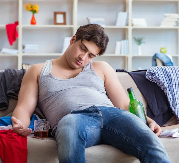 Il giovane studente ubriaco bere alcol in una stanza disordinata — Foto Stock