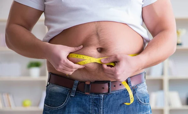 Homem que sofre de peso extra no conceito de dieta — Fotografia de Stock