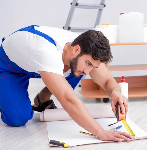 Reparador fazendo reparação de renovação na casa com papel wallpa — Fotografia de Stock