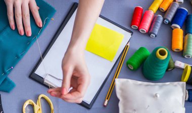 Kadın terzi dikiş dikmek için dikiş dikiyor.