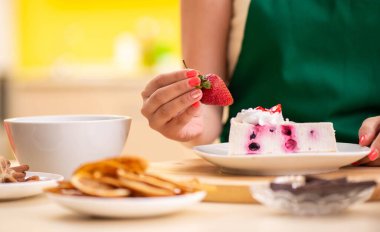 Genç aşçı mutfakta kek pişiriyor.