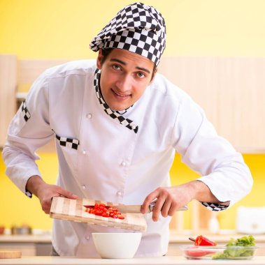 Genç profesyonel aşçı evde salata hazırlıyor.