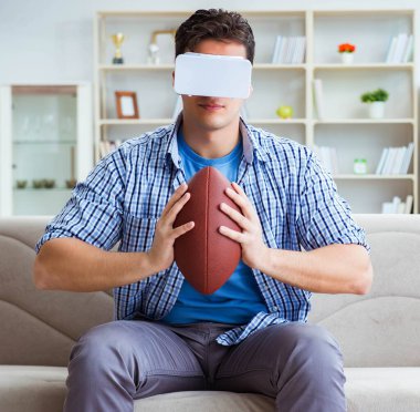 Sanal gerçeklik gözlüğü takan adam Amerikan futbolunu izliyor.