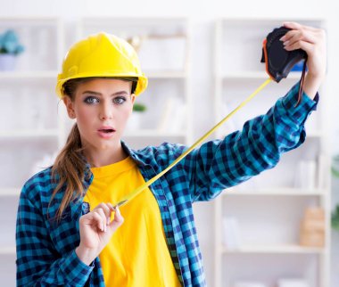 Atölyede elinde mezura olan kadın.