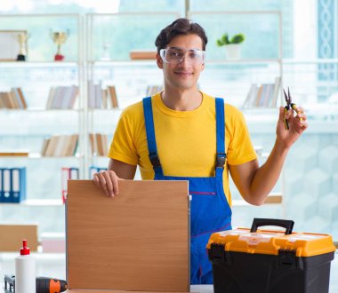 Mobilya marangozu atölyede çalışıyor.