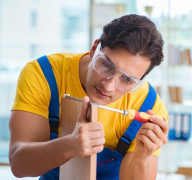 Mobilya marangozu atölyede çalışıyor.