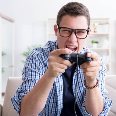 Genç adam evde bilgisayar oyunu oynuyor.