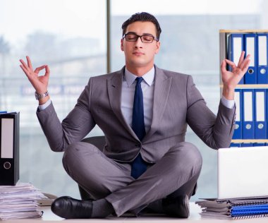 İşadamı ofiste meditasyon yapıyor.