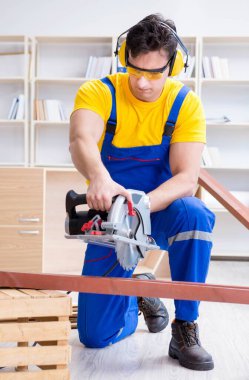 Tamirci marangoz. Dolaşım halindeki tahta testereyi kesiyor.