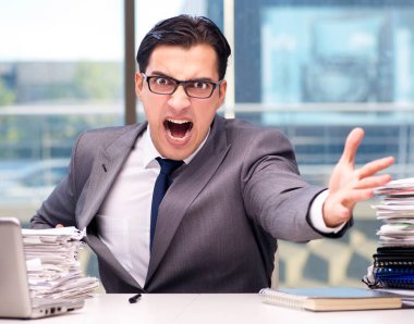Ofiste çok işi olan kızgın bir işadamı.