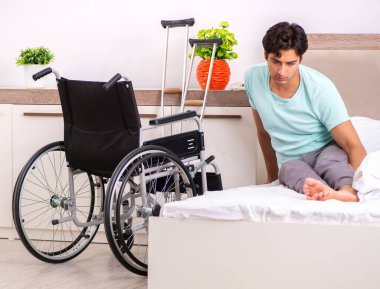 Genç yakışıklı engelli adam evde iyileşiyor.