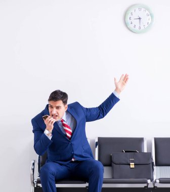 Havaalanı dinlenme odasında yolcu bekleyen adam.