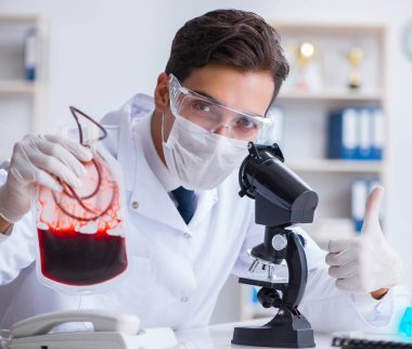 Hastane kliniğinde kan örnekleriyle çalışan bir doktor.