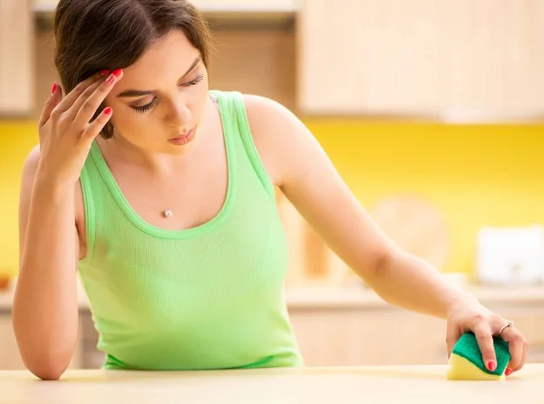 Young beatifull woman polishing table in the kitchen — Stock Photo, Image