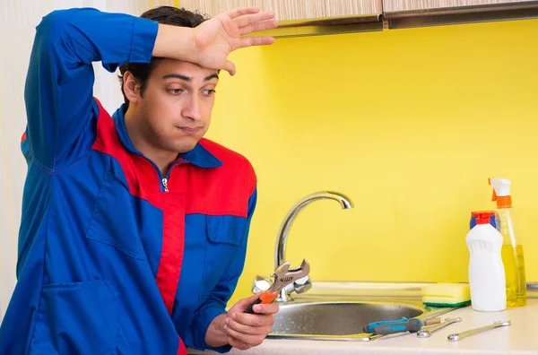 Plumber repairing tap at kitchen — Stock Photo, Image