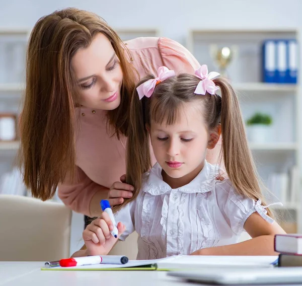 Mother helping her daughter to do homework — Stock Photo, Image