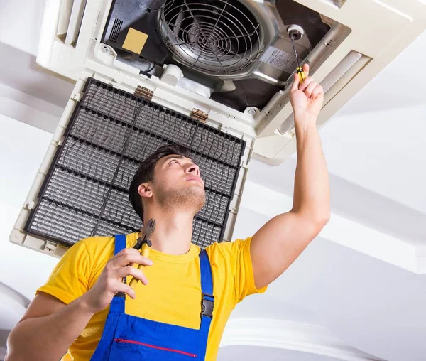 Reparador reparando la unidad de aire acondicionado del techo — Foto de Stock